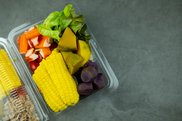 Many of fresh chopped fruits and vegetable for eating healthy salad in plastic box. Clean eating concept