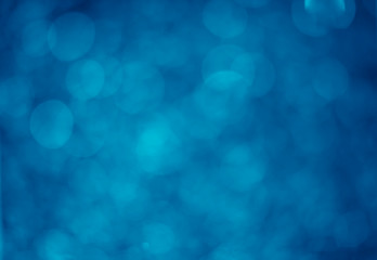 Blue glitter vintage lights background. White bokeh on blue background.