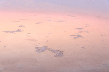 Beautiful landscape salt farm sunset refection on the water and salt crystal at Samutsakhon Thailand