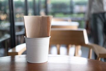 Brown tissue in white bucket on wood table