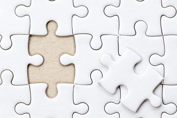 Closed up background of white plain jigsaw wait missing piece to match or fulfill