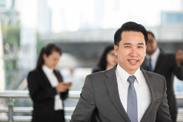 Portrait Of Smiling Businessman With Businessmen In Background