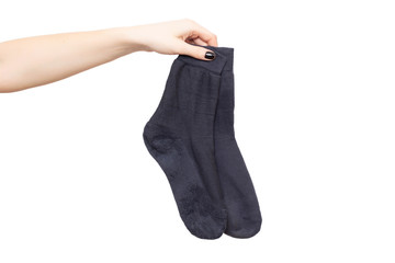Female hand holds black men's socks on a white background. The concept of unpleasant foot odor and fungal diseases on the legs. Antiperspirants against foot odor