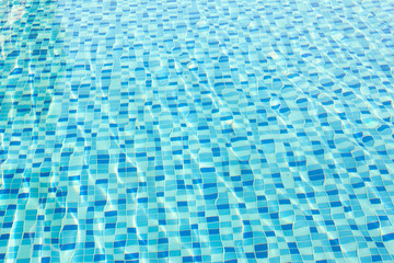 Ripple Water in swimming pool with blue tile floor background