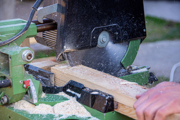 Man cutting wood using circular saw to create different products out of wood