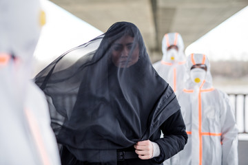 People with protective suits outdoors, coronavirus and death concept.
