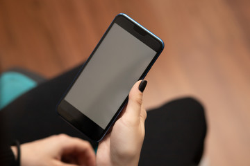Female hand holds a mobile phone mockup