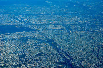 Aerial shot of the city of Paris up high from a plane with main landmarks visible like the Eiffel Tower or Arc de Triomphe