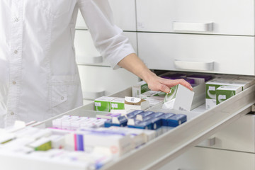 Pharmacien tenant une boîte à médicaments et un pack de capsules dans une pharmacie de pharmacie.
