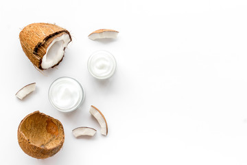 Skin care cream with coconut oil on white background top-down frame copy space