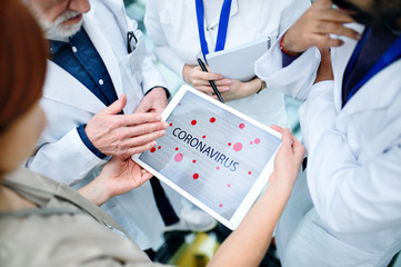 Group of doctors talking about corona virus on conference, midsection.