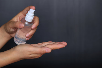 Coronavirus (COVID-19),Woman hand holding a gel in the bottle or disinfectant on black background