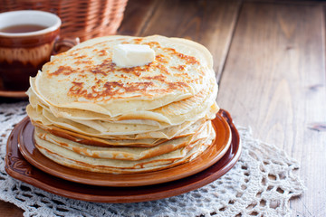 Homemade thick pancakes stacked on a plate, horizontal, copy space