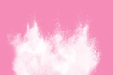 Abstract white powder explosion. Closeup of white dust particle splash isolated on pink  background.