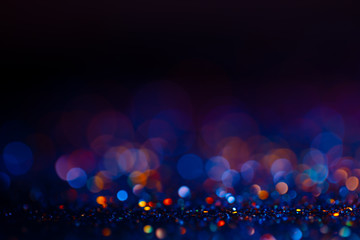 Festive bokeh glitters background, abstract blurred backdrop with circles,modern design wallpaper with sparkling glimmers. Black, blue and golden backdrop glittering sparks with blur effect