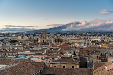 Catania, Sicily, Italy. View of the mount Etna from a rooftop of the baroque old city center. Landscape at the sunset. - obrazy, fototapety, plakaty