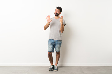 Fototapeta na wymiar A full-length shot of handsome man with beard counting eight with fingers