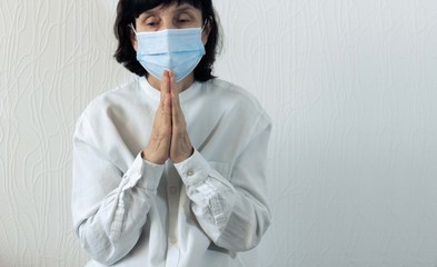 Coronavirus quarantine and Air pollution pm2.5 concept. Old sick woman wearing blue respirator mask for protect and praying to god. Wuhan, China epidemic virus symptoms background.
