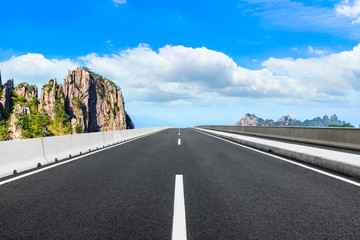 Empty asphalt road and green mountain with beautiful clouds.