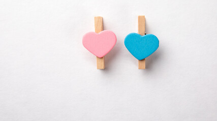 Wooden clips with Blue and Pink hearts. White background
