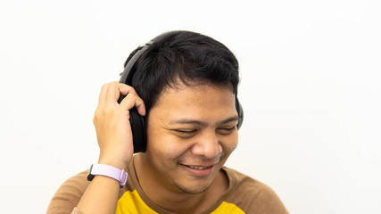 Close-up portrait of happy Asian man smiling while enjoying listen to music on white isolated background.