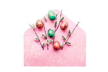 Bright green and red easter quail eggs and fluffy willow branches in a pink envelope on white isolated background, top view. Easter background. 