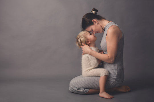Young mother, hugging her beautiful blond toddler boy