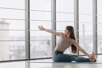 Fototapeta na wymiar pretty attractive girl doing yoga and relaxing in the bright room