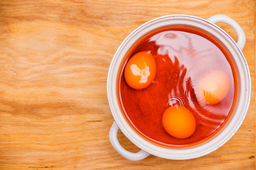 Eggs are painted red in a pan. Easter preparation