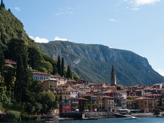 Fototapeta na wymiar panoramic view of mountains and Varenna city from ferry, Como lake, Lombardy, Italy