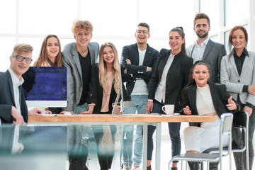 team of young professionals standing near the desktop