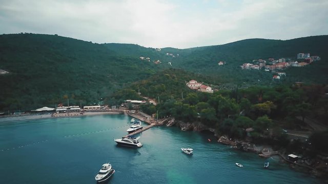 Yachts are sailing on the sea on the greenery island background