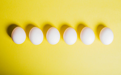 Eggs are arranged in row along bottom edge on yellow background, copy space. Happy Easter DIY...