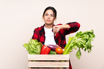 Farmer Woman holding fresh vegetables in a wooden basket showing thumb down sign