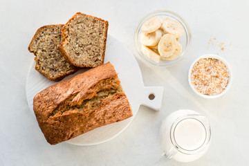 Banana bread with coconut and milk on a light gray background. Homemade delicious pastries. Top view, close- up, copy space.