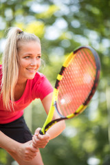 Pretty, young woman tennis player playing on a clay court. Healthy active lifestyle concept