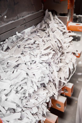 A paper recycling factory plant shredding machine, shredding waste paper into square bails, ready...