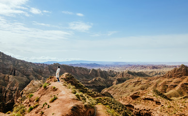 Young girl enjoys the view of valley on top of hill