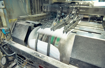 A industrial commercial envelope making machine, making paper envelopes for international distribution. Automated engineering machinery for mass production of paper envelopes.