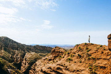 Young girl enjoys the view of valley on top of hill