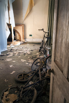 Abandoned farmhouse with vintage bikes and peeling wallpaper