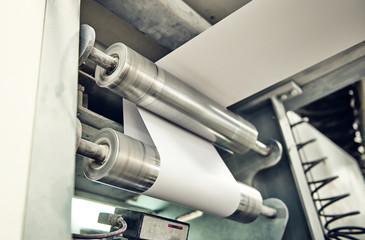 A industrial commercial envelope making machine, making paper envelopes for international distribution. Automated engineering machinery for mass production of paper envelopes.