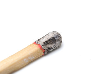 Burned matchstick head close up with a white background