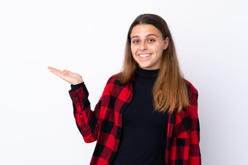 Teenager girl over isolated white background holding copyspace imaginary on the palm to insert an ad