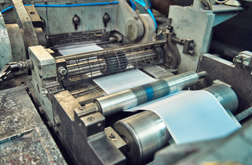 A industrial commercial envelope making machine, making paper envelopes for international distribution. Automated engineering machinery for mass production of paper envelopes.