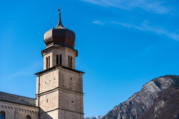 Fototapeta na wymiar Closeup of the San Vigilio Cathedral (Duomo di Trento, 1212-1321) with the bell tower. In the background the Alps in winter, Trento, Trentino-Alto Adige, Italy, Europe