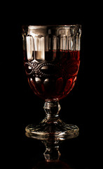 wine glass with red wine on a black background