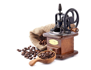 Coffee mill with Coffee beans in a wooden spoon on white background.