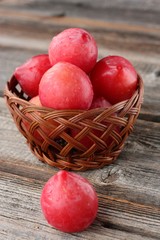 Fresh red plums on a wooden table 