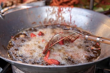 fried chicken wings are cooked in boiling oil. colander ladle for stirring. Thai street food